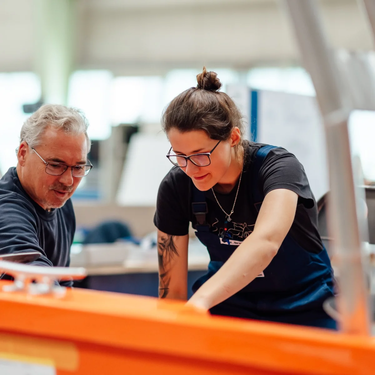 Two Fassmer employees working together on a shipbuilding component in the shipyard. Teamwork and hands-on experience in shipbuilding.